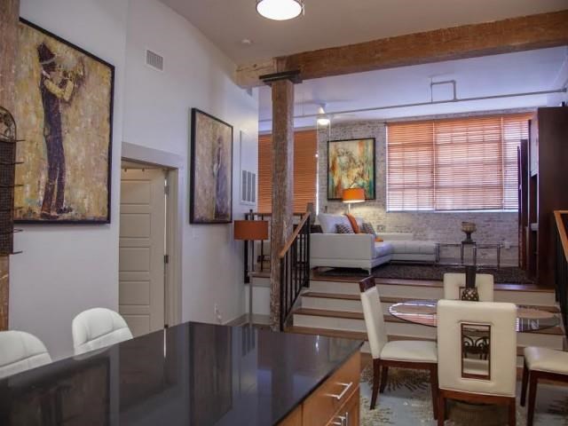 a living room and dining room with a table and chairs