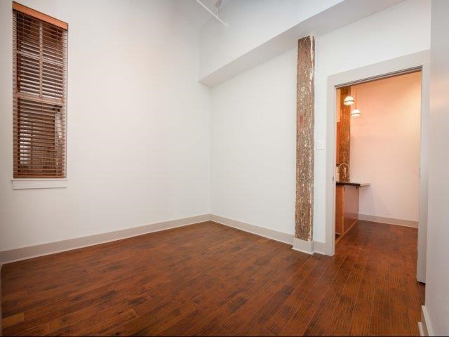 an empty room with a wood floor and white walls