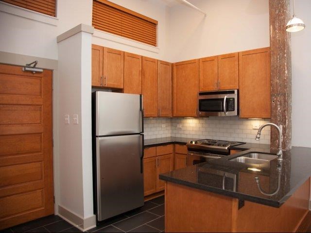 a kitchen with a stainless steel refrigerator and a sink