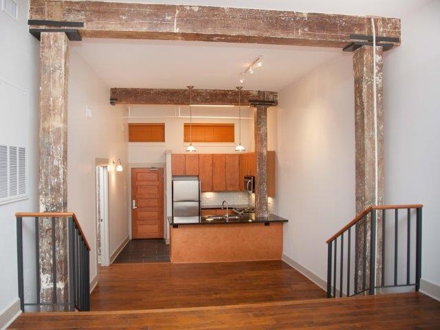 a living room with a kitchen and a staircase