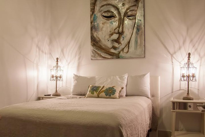 a bedroom with a bed and a painting on the wall