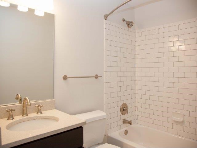 a white bathroom with a sink and a tub and a toilet
