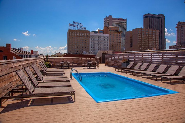 a swimming pool on top of a deck with chairs