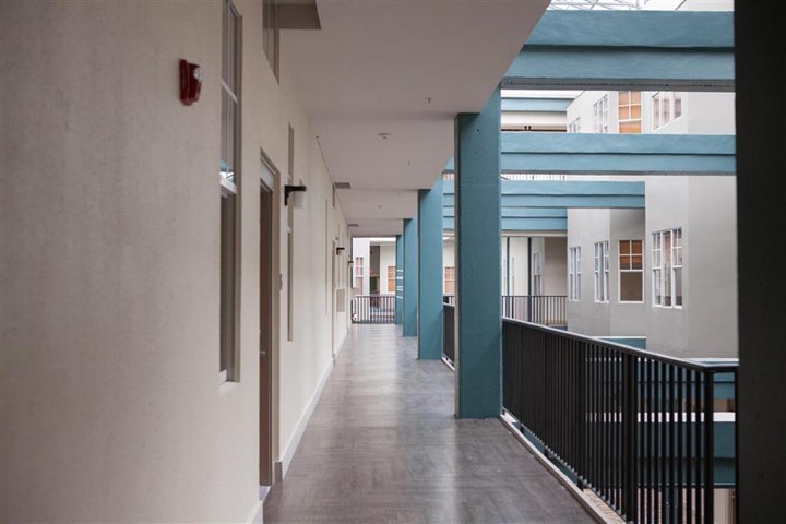 a hallway in a building with blue pillars