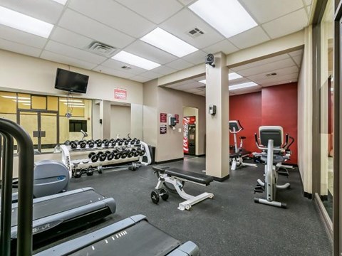 a gym with a lot of chairs and weights