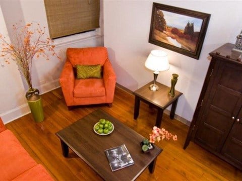 a living room with a orange chair and a table
