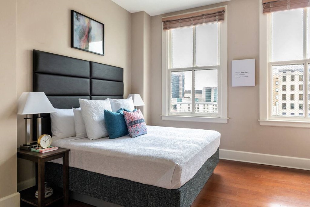 a bedroom with a bed and two windows