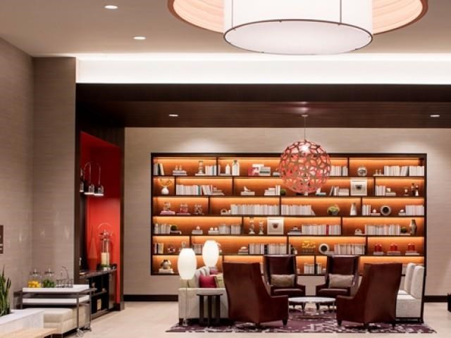 the lobby of a hotel with a reception desk and chairs