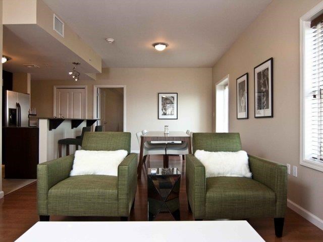 a living room with two green chairs and a table