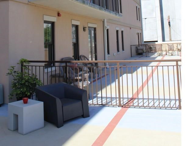 a balcony with a blue chair and a table