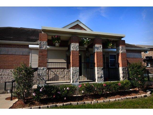 the front of a brick house with a black fence