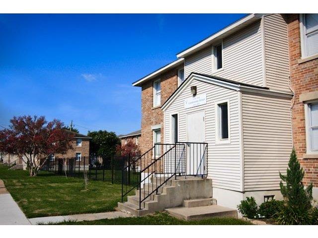 a white house with a black railing on the steps
