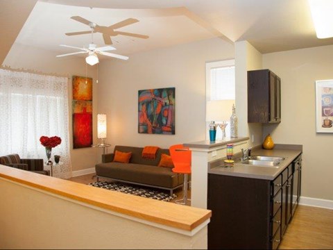 a living room and kitchen with a ceiling fan
