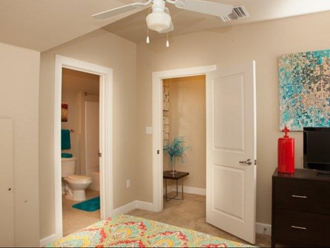 a bedroom with two doors and a bathroom with a toilet