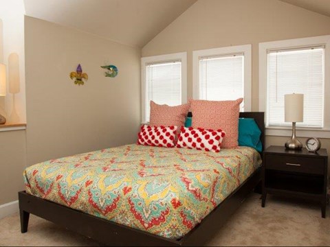 a bedroom with a bed and three windows