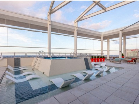 a swimming pool on the top of a building with chairs
