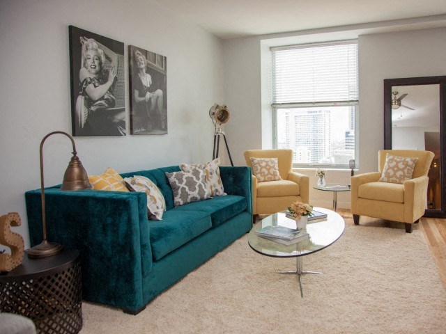 a living room with a blue couch and two yellow chairs