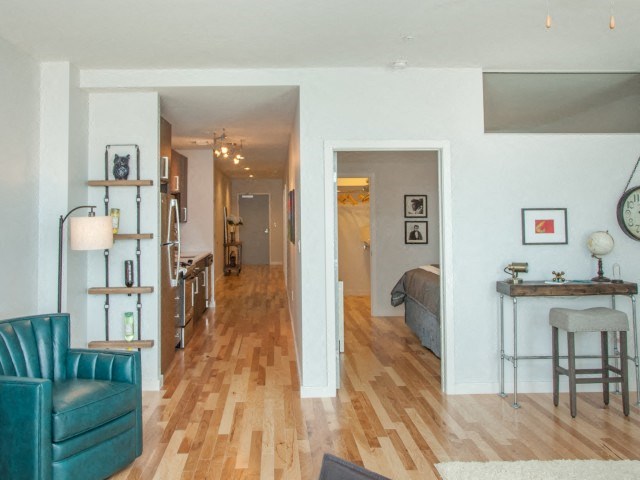 a living room and a bedroom with a wood floor