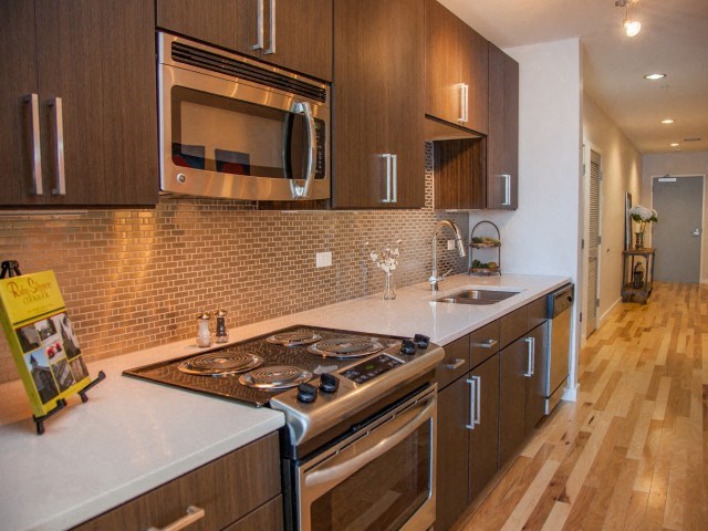 a kitchen with a stove and a sink and a microwave