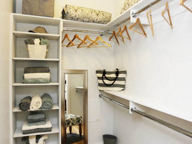 a closet with shelves and racks and a mirror