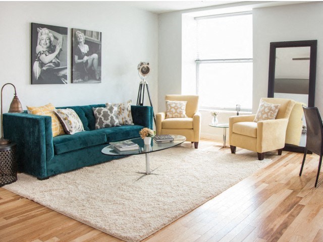 a living room with a green couch and two yellow chairs