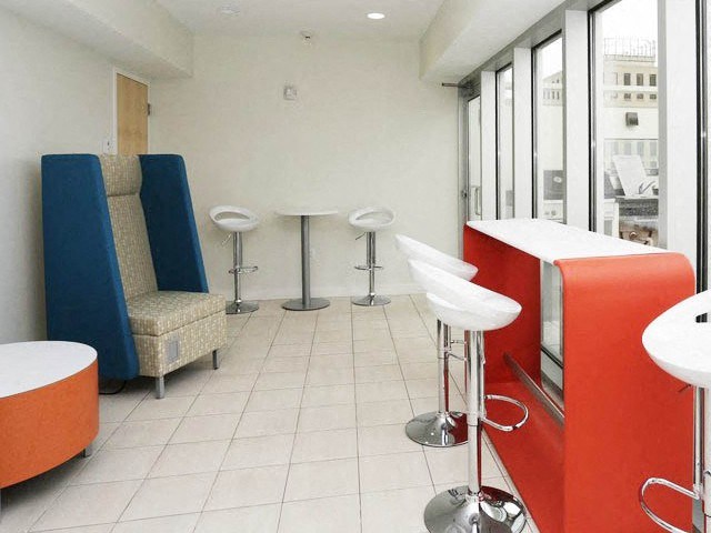 a waiting room with chairs and a counter in front of a window