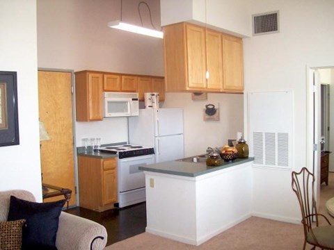 A kitchen with wooden cabinets and a white fridge.