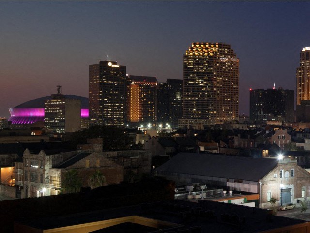 a city skyline at night with a purple light on the building