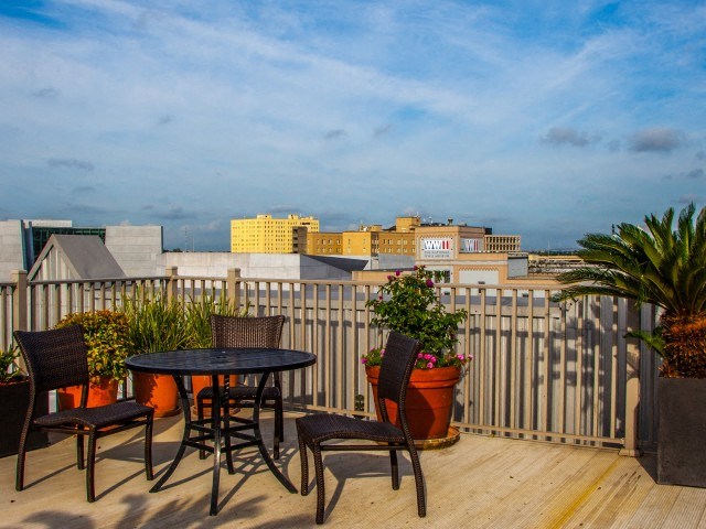 a balcony with a table and chairs and a view of the city