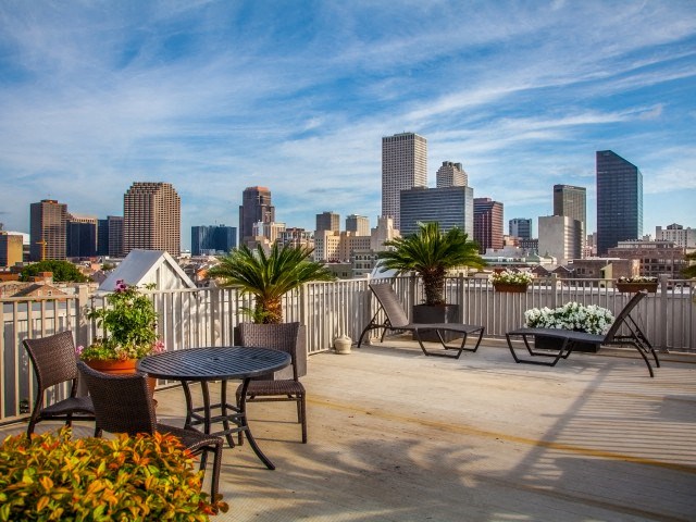 a roof deck with tables and chairs and a view of the city