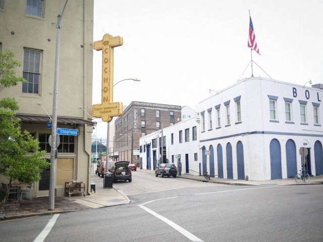 a city street with a cross on the side of a building