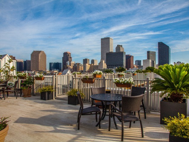 a roof deck with a table and chairs and a view of the city