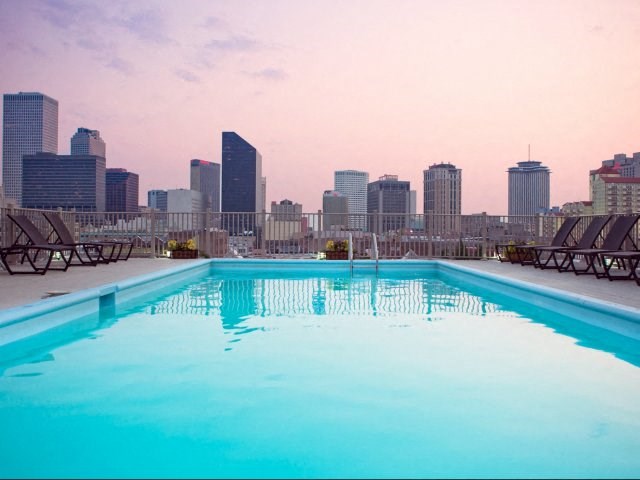 a swimming pool with a city skyline in the background
