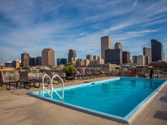 the pool on the roof of a building with a city skyline