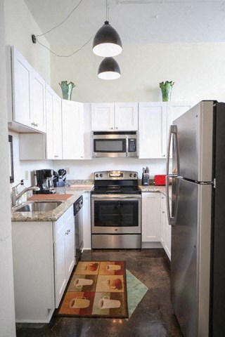 a kitchen with stainless steel appliances and white cabinets