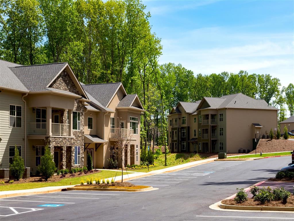 an empty parking lot in front of some apartment buildings