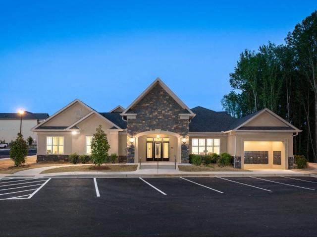 a house with lights on in a parking lot