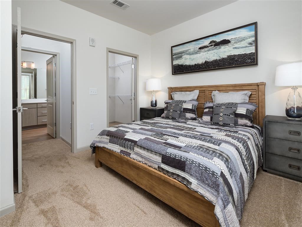 a bedroom with a bed and a door to a bathroom