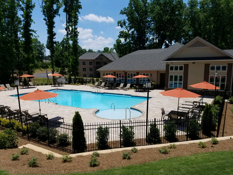 a large swimming pool with umbrellas in front of a building