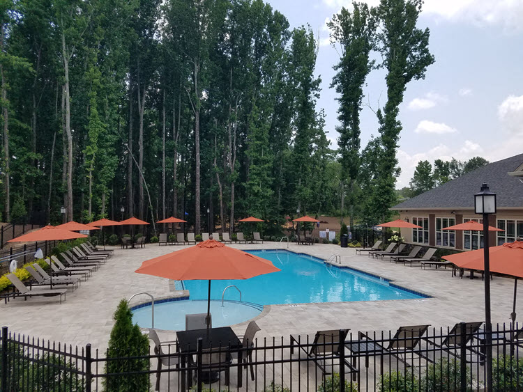 a swimming pool at a resort with chairs and umbrellas