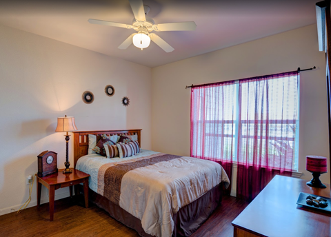 a bedroom with a bed and a ceiling fan