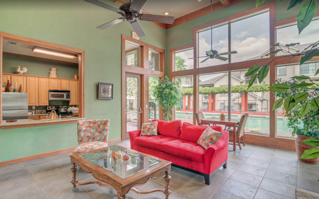 a living room with a red couch and a glass coffee table