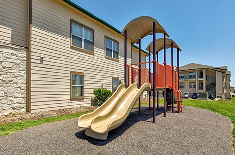 a playground with a slide in front of a building