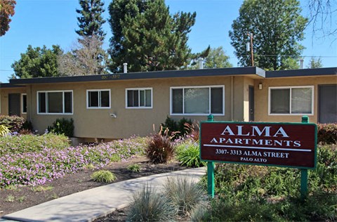 an alma apartments sign in front of a building