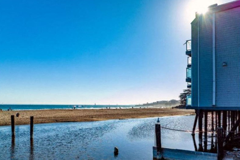 A sunny day at the beach with a building on the right side.