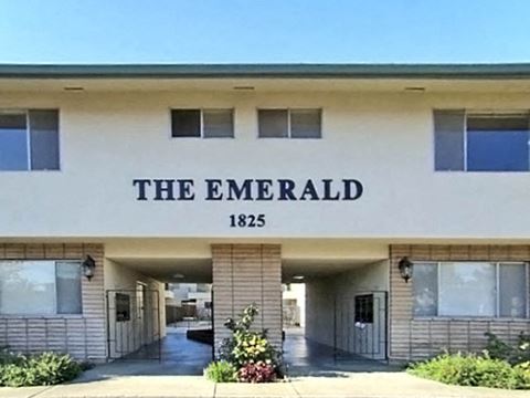 the emerald apartment building with a sign on the front of it