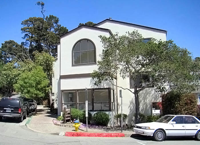a white building with cars parked in front of it
