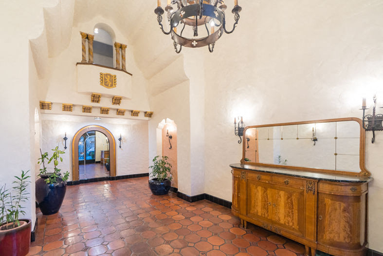 the lobby of a hotel with a reception desk and a chandelier