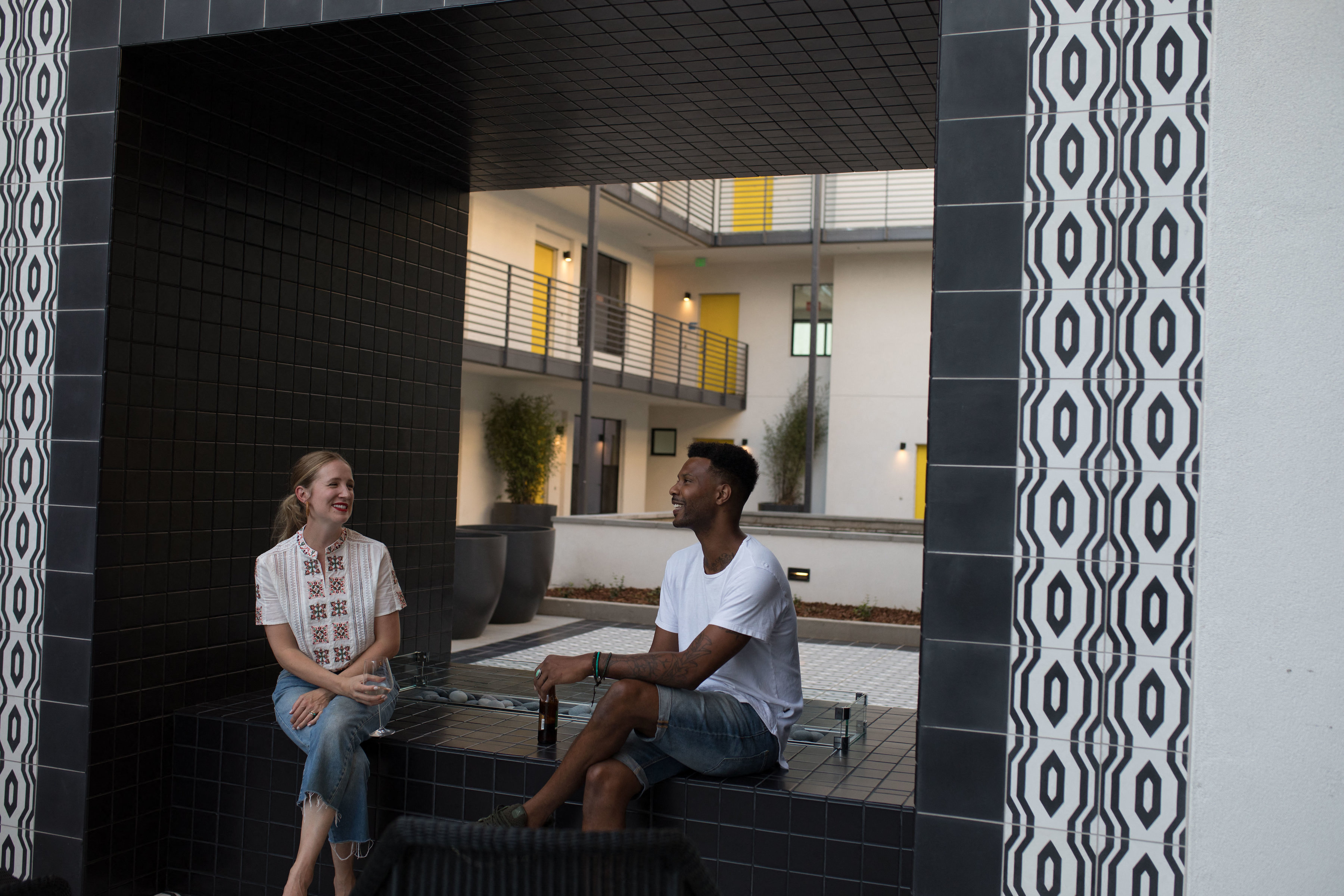 two people sitting on a bench in front of a building