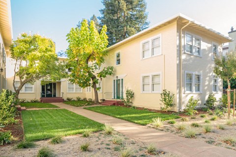 a house with a sidewalk and lawn in front of it
